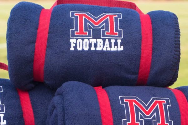 Collection of custom school and team fleece blankets featuring embroidered team logos and school colors.